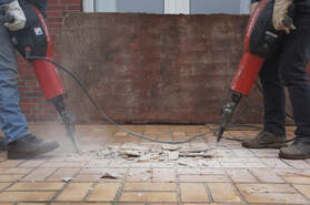Picture of two guys drilling into the floor.